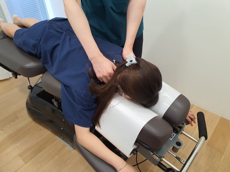 엎드린 환자의 목을 치료하는 모습