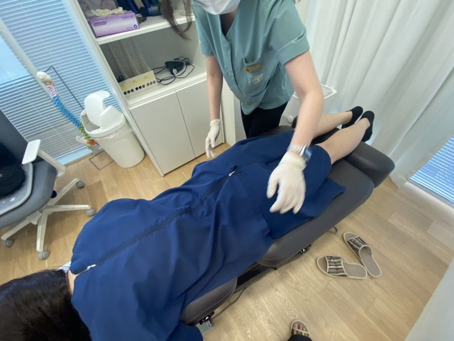엎드린 환자의 다리를 의료진이 잡아 검사하는 사진